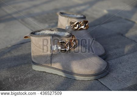 Fashionable Female Boots Resting On The Pavement