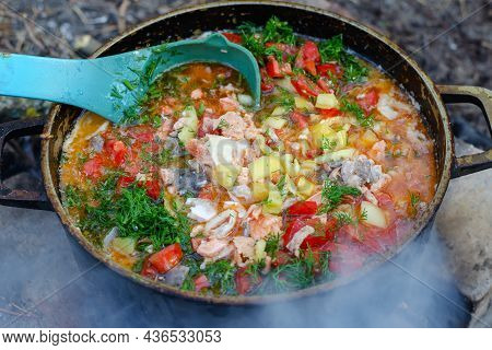 Traditional Fisherman's Soup Over A Campfire. Ukha Of Fish And Vegetables. Sturgeon, Salmon, Rooster