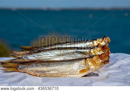 Smoked Sprattus Or Sprats Sea Fish Served Outdoor With View On Blue Sea Water