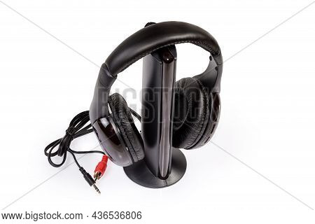 Black Modern Wireless Full Size Closed-back Headphones Hanging On Its Emitter On A White Background