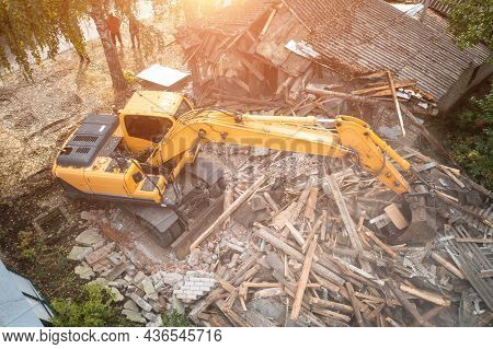 Excavator Breaks Old House, Many Dust In Air. Building Demolition And Deconstruction, Aerial View.