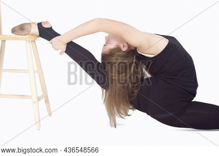 Athletic Caucasian Sportswoman Rhythmic Gymnast In Training Outfit During Legs Backward Stretching E