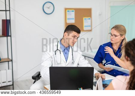 A Doctor And A Lady Doctor Are Discussing An X-ray Of Their Patients Lungs.