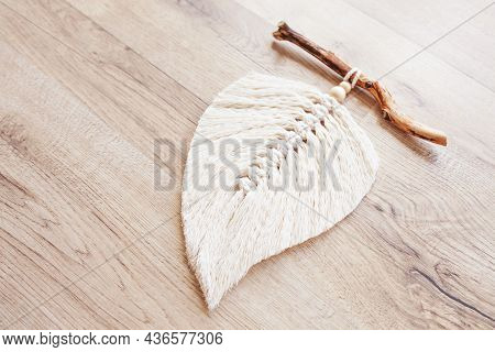 Macrame Leaf  In Natural Color And Thread Windings Lying On A Wooden Table. Cotton Rope Decor Macram