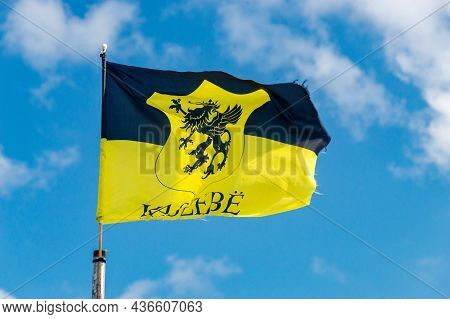 Kashubia Flag With Coat Of Arms Of Kaszebe On Blue Sky.