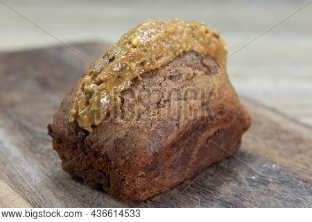 Freshly Baked Loaf Of Banana Bread Slathered With Pistachio Butter And Served On A Wooden Platter.