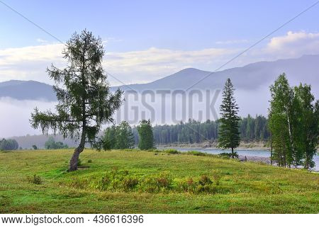 A Foggy Morning Among The Mountains Under A Blue Cloudy Sky. Siberia, Russia