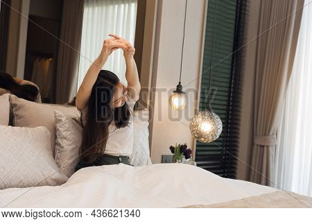 Asian Woman Stretching As She Wakes Up In The Morning.
