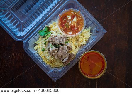 Roasted Meat Served With Rice And Chillies Tamarind Sauce And Curry Gravy In A Take Out Container. M