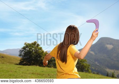 Woman Throwing Boomerang In Mountains, Back View. Space For Text
