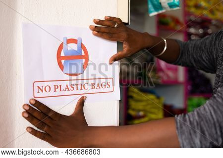 Closeup Shot Of Unrecognizable Shopkeeper Pasting No Plastic Bag Notice On Wall - Concept To Reduce 