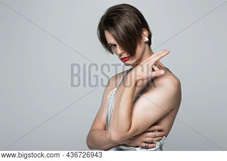 Transgender Man With Red Lips And Earring Posing In Slip Dress Isolated On Gray