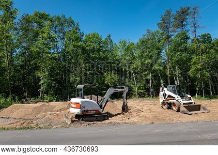 Crow Wing Co, Mn - 6 Jun 2021: A Bobcat Mini Excavator And Front Loader, With Skid Steer Tracks, Sit