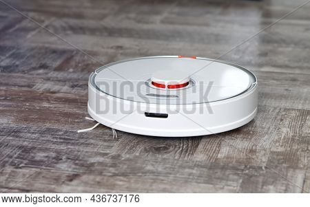 Robot Vacuum Cleaner Performs Automatic Cleaning On Wooden Floor Close Up