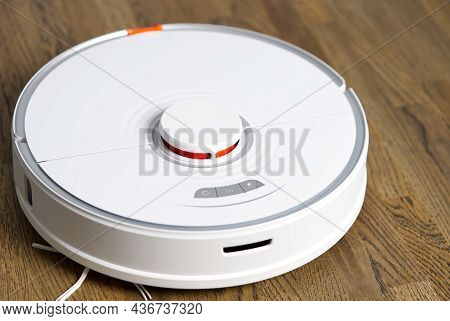 Robot Vacuum Cleaner Performs Automatic Cleaning On Wooden Floor Close Up