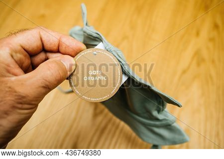 Lyon, France - May 2, 2021: Pov Male Hand Father Holding Infant Baby Clothes Manufactured By The Swe