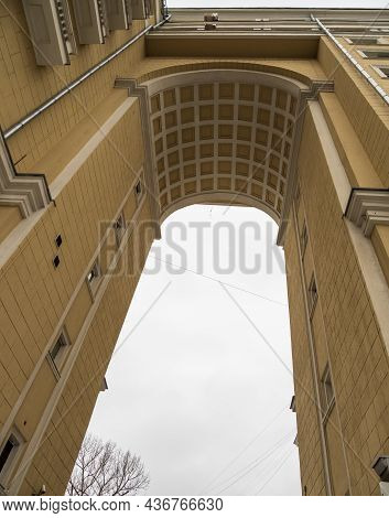 High Arched Doorway In An Old Multi-storey Building. Multi-storey Yellow Residential Building In Cen