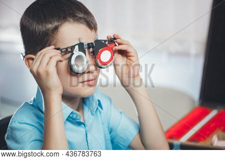 Optometrist Selects Glasses For Vision Correction Of Small Child. Concept Of Visual Impairment In Ch