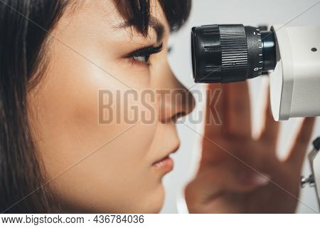 Researcher Doctor Looks Into The Microscope, Conducting An Experiment. Medical Research. Pharmacolog