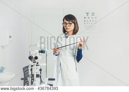 Doctor Ophthalmologist Holding Lenses To Check Patient's Vision. Focus On Lens, Face Is In Soft Focu