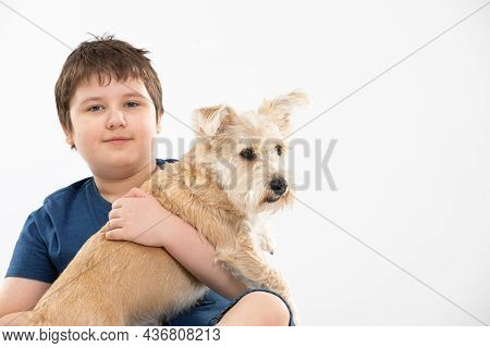 Young Boy Holds His Dog In His Arms. Subject Isolated From The Background.
