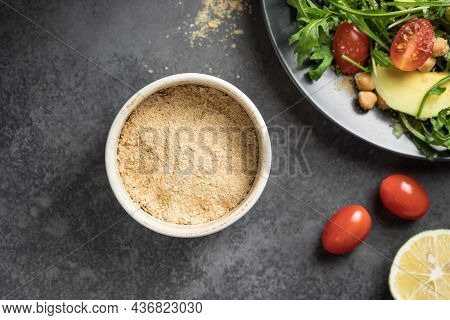 Gluten Free Nutritional Yeast Flakes In Ceramic Bowl. Ingredient For Vegan Food. Closeup, Copy Space