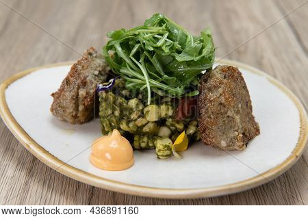 Hearty Plate Of Roasted And Fried Crab Cakes With A Dallop Of Sauce And Arrranged On A Plate With Ar
