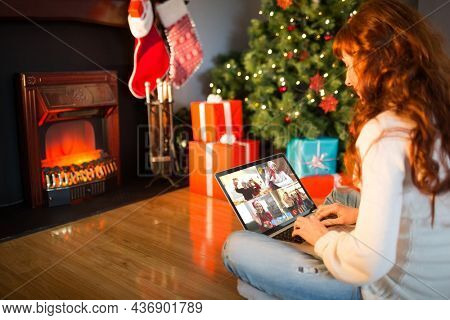 Caucasian woman on christmas laptop video call with diverse group of friends. christmas, festivity and communication technology.