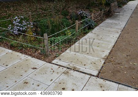 Park Square With Gravel Compacted Paths And Concrete Sidewalk. A Metal Slot Gutter Is Used For Drain