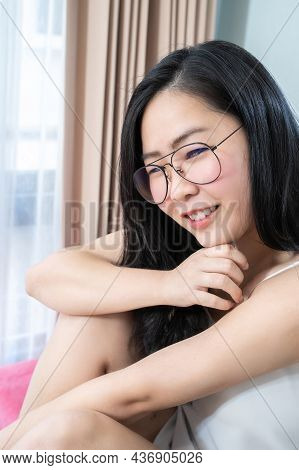 Asian Glasses Woman Relax On Her Bed In The Morning At Her Bedroom.