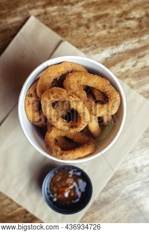 Close-up Of Onion Rings In Batter. Fried Vegetables At A Fast Food Restaurant. Vegetarian Cuisine In
