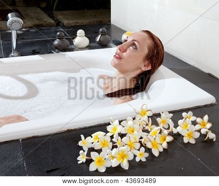 ผู้หญิงวางใน soapsuds ในการอาบน้ำที่เต็ม