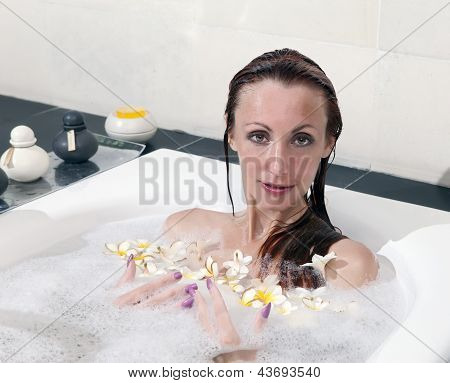 ผู้หญิงวางใน soapsuds ในการอาบน้ำที่เต็ม