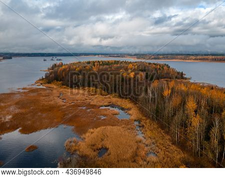 Aerial View Of Island With Trees With Yellow And Orange Foliage In The Middle Of The Lake. Blue Clou