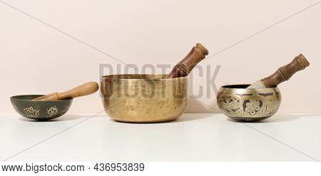 Copper Singing Bowl And Wooden Clapper On A White Table. Musical Instrument For Meditation, Relaxati