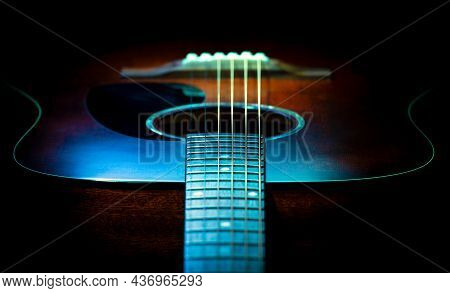 Blue And Orange Colored Closeup Of A Classical Guitar's Soundhole, Soundboard, Neck, Fretboard And S