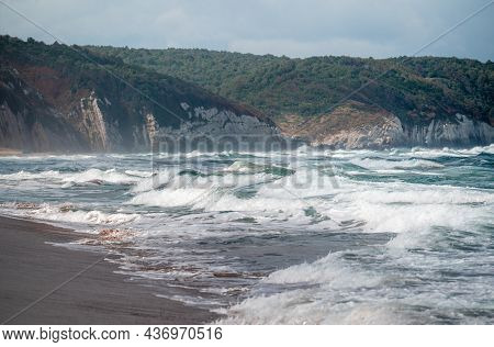 Beautiful Sandy Ocean Beach With Large Rocks On The Shore And In The Water. Powerful Waves On Ocean.