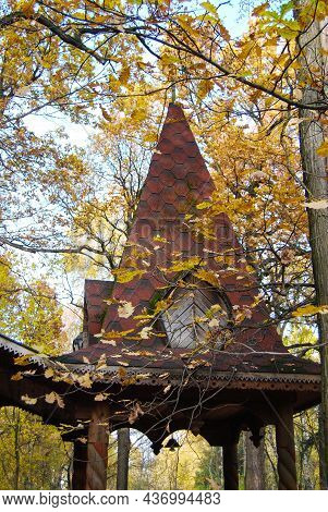 The Roof Of The Porch Of An Old Wooden Hut In Autumn. The Gabled Roof Of The Porch Is Surrounded By 