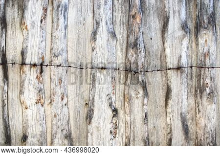 Texture Of An Old Fence Made Of Dried And Cracked Wooden Panels With Rusty Barbed Wire On Top Of It 