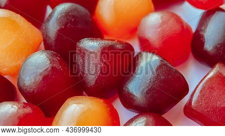Close-up Texture Of Red, Orange And Purple Multivitamin Gummies On White Background. Healthy Lifesty