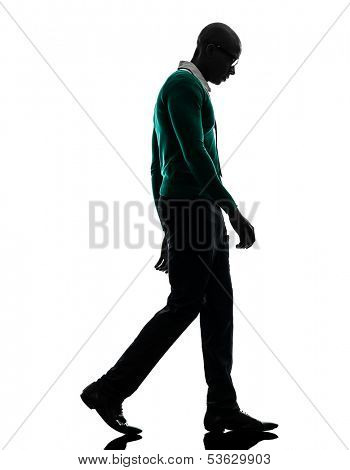 one african  black man walking looking down sad  in silhouette studio on white background