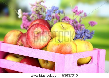 Juicy apples in box on natural background