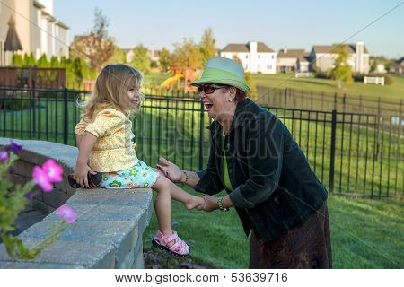 Frolicsome Toddler Girl Hiding Her Shoes From Her Grandmother