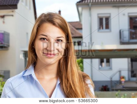 Portrait of a young woman in front of a building