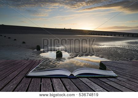 Creative Concept Pages Of Book Vibrant Sunrise Landscape Reflected In Low Tide Water On Beach