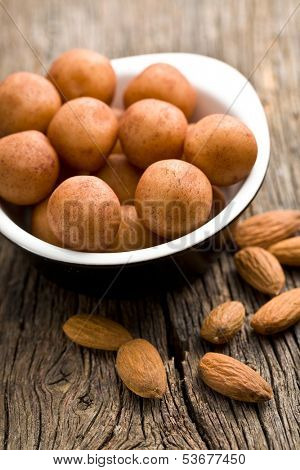 marzipan balls and almonds on old wooden table
