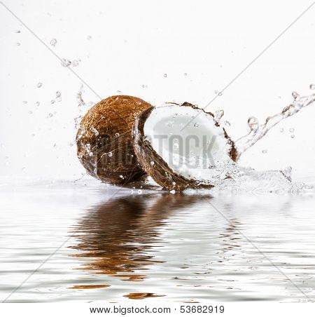 cracked coconut with big splash, isolated on white