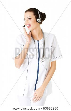 Young attractive nurde with stethoscope and headphones and microphone. Isolated on white. 