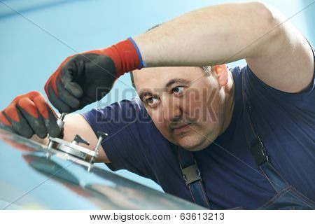 Automobile glazier repair windscreen or windshield of a car in auto service station garage