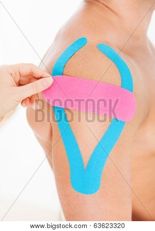 Person Applying Physio Tape To Man